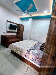 een slaapkamer met een bed, een bank en een tv bij Hotel Morning Star in Bathinda