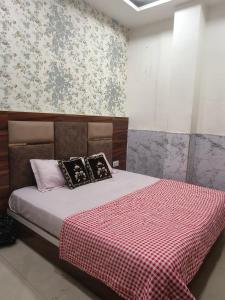 een slaapkamer met een bed met een rood-witte deken bij Hotel Morning Star in Bathinda