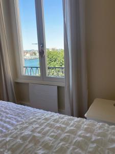 a bedroom with a bed and a window with a view at Appartement Vu Rhône - Vienne Centre in Vienne