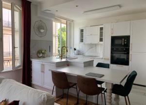 eine Küche mit Tisch und Stühlen in einem Zimmer in der Unterkunft Appartement Vu Rhône - Vienne Centre in Vienne + 3 Fotos