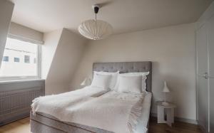 a bedroom with a bed with white sheets and a window at TwentySix in Malmö