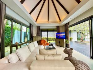 un salon avec un canapé blanc et une télévision dans l'établissement Luxury Pool Villa Resort Style Near Laguna Area, à Laguna Phuket