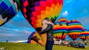 a couple hugging under a bunch of hot air balloons at Hotel Centro dos Canyons in Praia Grande