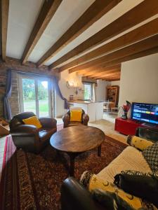a living room with couches and a table and a kitchen at Gite cosycool in Languidic