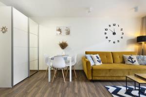 ein Wohnzimmer mit einem gelben Sofa und einem Tisch in der Unterkunft Cozy Beachside Falla by Elite Apartments in Zaspa