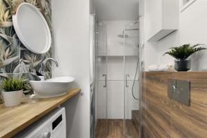 ein Badezimmer mit Waschbecken und Dusche in der Unterkunft Cozy Beachside Falla by Elite Apartments in Zaspa