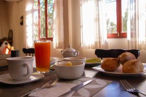 a table with plates of food and a glass of orange juice at La Parada  +33 photos