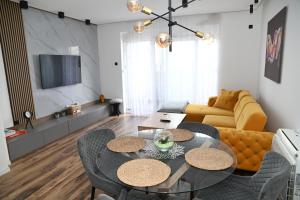 a living room with a couch and a table and chairs at Leotar View Apartment in Trebinje