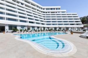 Un gran edificio con piscina en frente de un edificio. en AKOYA HOTEL, en Eilat