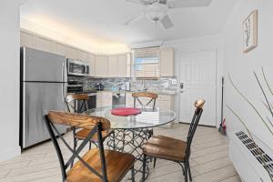 een keuken met een tafel, stoelen en een koelkast bij Penthouse On The Bay 4002 in Bonita Springs