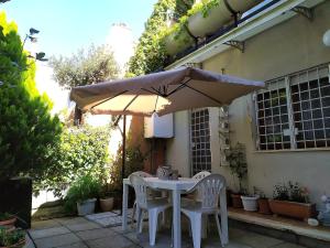 a white table and chairs under an umbrella at Mare, Roma e Aeroporto - Tutto a portata di mano in Fregene