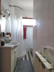 a white bathroom with a sink and a toilet at Mare, Roma e Aeroporto - Tutto a portata di mano in Fregene +16 photos