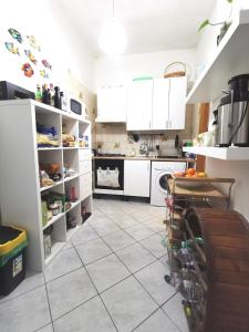 a kitchen with white cabinets and a tile floor at Mare, Roma e Aeroporto - Tutto a portata di mano in Fregene