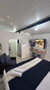 a bedroom with a large bed and a couch at Suites a 5min da Broadway in Aracati