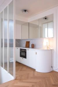 a white kitchen with white cabinets and a counter at Hotel Montaigne in Ostend