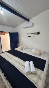 a bedroom with a large bed with towels on it at Suites a 5min da Broadway in Aracati