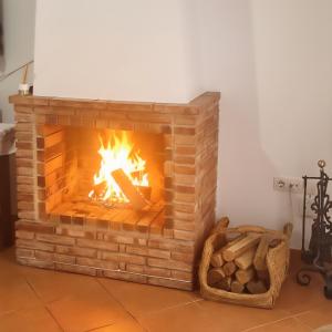a brick fireplace with a fire in it at Casa Curro in Benaocaz
