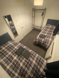 deux lits dans une chambre avec un miroir dans l'établissement Home in Ty Canol, Cwmbran, à Cwmbrân