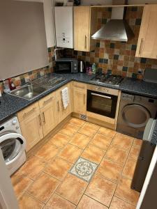 une cuisine avec un évier et une machine à laver dans l'établissement Home in Ty Canol, Cwmbran, à Cwmbrân