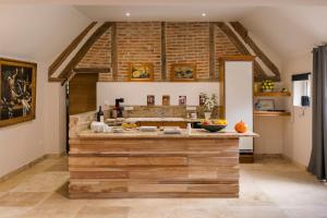a kitchen with a large counter with a brick wall at Gîte du Dreuillet Charme & nature en Sologne in La Celle-sous-Gouzon