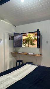 a bedroom with a desk and a window with a table at Suites a 5min da Broadway in Aracati +12 photos