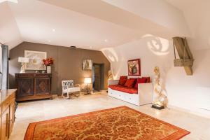 a large living room with a red couch and a table at Gîte du Dreuillet Charme & nature en Sologne in La Celle-sous-Gouzon
