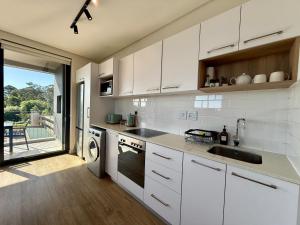 a white kitchen with a sink and a dishwasher at Urban Escape - Le Jardin Unit 301 in George