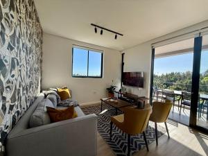 a living room with a couch and a table and a television at Urban Escape - Le Jardin Unit 301 in George