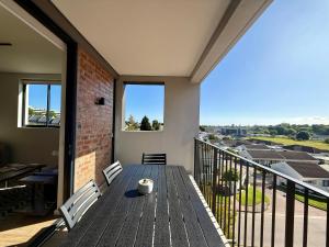 a porch with a wooden table and chairs on a balcony at Urban Escape - Le Jardin Unit 301 in George