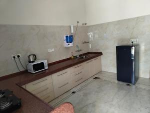 a kitchen with a refrigerator and a microwave at Medhya Boutique Homestay in Udaipur