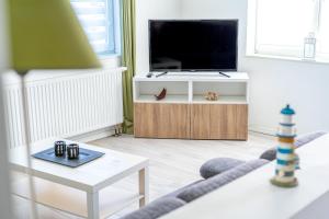 TV a/nebo společenská místnost v ubytování Kajütenhus Komfort-Ferienwohnungen