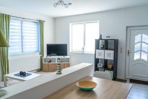 TV a/nebo společenská místnost v ubytování Kajütenhus Komfort-Ferienwohnungen + 38 fotografií