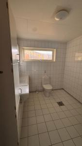 a bathroom with a toilet and a sink and a window at Rørvikjordet 12 flott hus ved utsikt in Drammen +16 photos