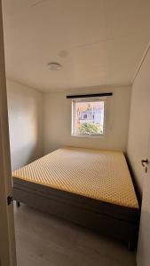a bed in a small room with a window at Rørvikjordet 12 flott hus ved utsikt in Drammen