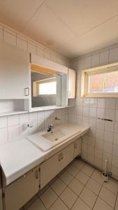 a white kitchen with a sink and a window at Rørvikjordet 12 flott hus ved utsikt in Drammen