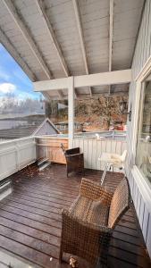 a porch with two chairs and a table on a deck at Rørvikjordet 12 flott hus ved utsikt in Drammen