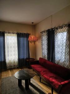 een woonkamer met een rode bank en een tafel bij 360 Agonda in Agonda