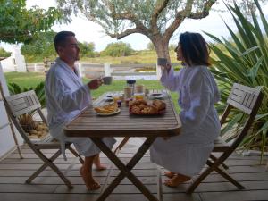 a man and woman sitting at a table with a plate of food at Mas des Rièges & Spa in Saintes-Maries-de-la-Mer