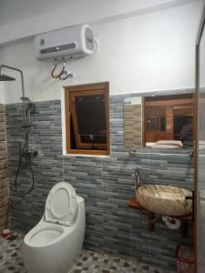 a bathroom with a toilet and a sink and a tub at Tay Na Bon Homestay in Làng Lap