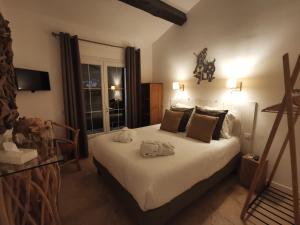 a bedroom with a bed with a dog sitting on it at Mas des Rièges & Spa in Saintes-Maries-de-la-Mer +92 photos