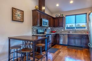 a kitchen with wooden cabinets and a island with bar stools at Hull Street Loft in Hood River