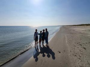 een groep van drie personen op het strand bij 8 person holiday home in Ålbæk in Ålbæk