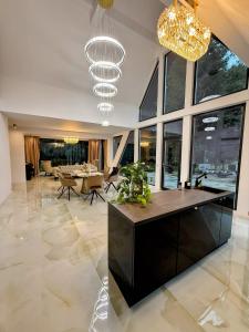 a large living room with a dining table and a chandelier at Pine Hill 2 in Poiana Mărului