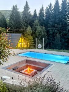 a fire pit in a yard next to a pool at Pine Hill 2 in Poiana Mărului