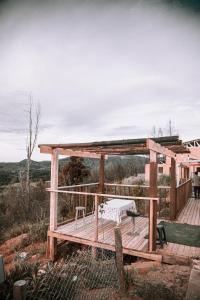 a wooden deck with a bench and a table at Dollinco Lodge in El Cerrillo