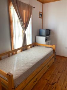 a bedroom with a wooden bed with a window at La Vita CdelU in Concepción del Uruguay