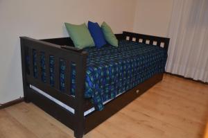a bed with blue and green pillows in a room at Mendoza pleno centro in Mendoza