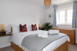 a bedroom with a bed with towels on it at Coastal Home for 6 in The Witterings in East Wittering