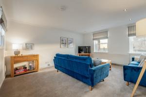a living room with two blue couches and a tv at Murray's Neuk in Anstruther