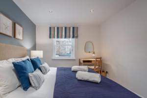a bedroom with a large bed with blue pillows at Murray's Neuk in Anstruther